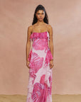 A female model wearing a pink floral maxi gown with spaghetti straps.