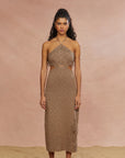 A model wearing a brown mid-length knit dress with a halter neckline and cut-out waist