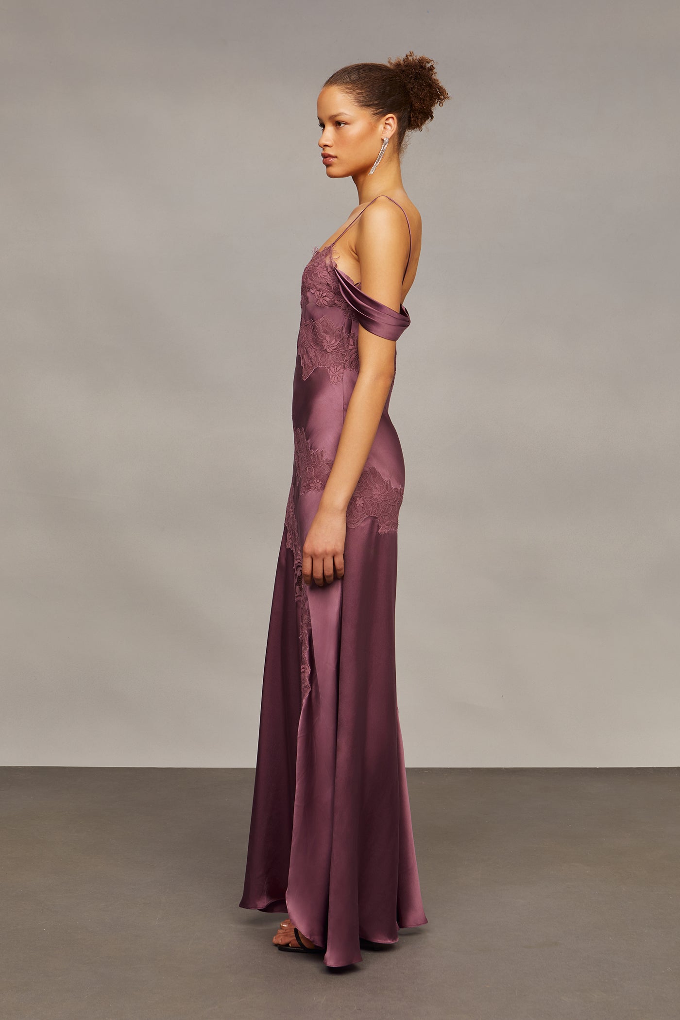 Woman wearing a long purple dress against a neutral background