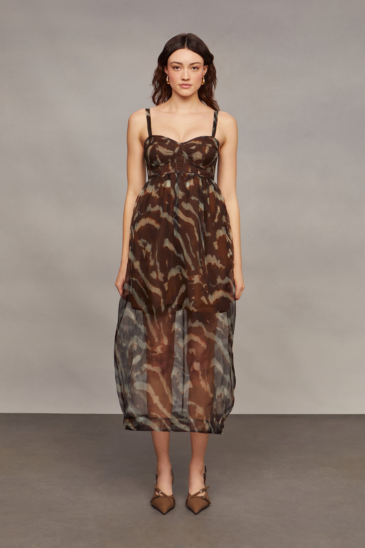 Woman wearing a patterned dress against a plain background