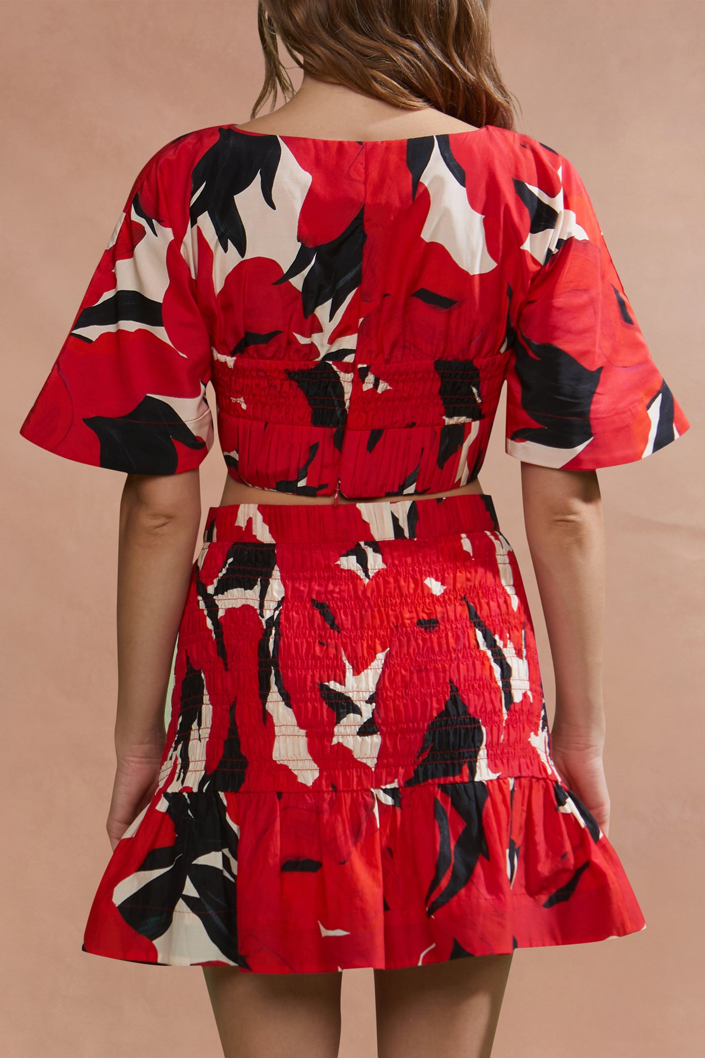 Red floral dress with black and white pattern on a beige background