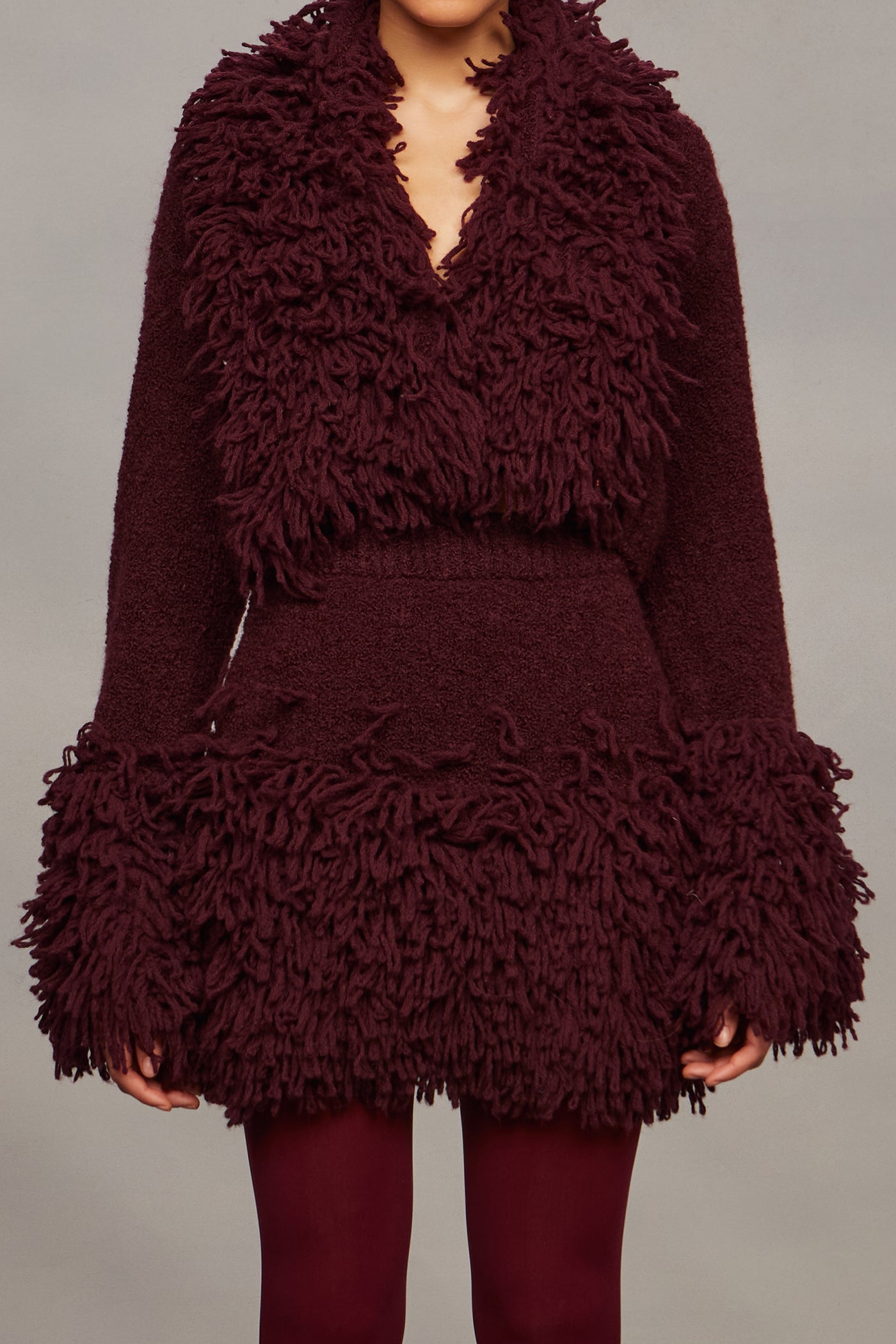 Maroon textured dress on a plain background