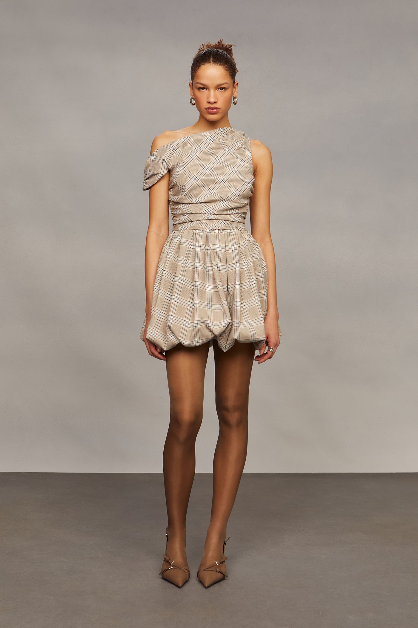 Woman wearing a patterned off-shoulder dress against a plain background