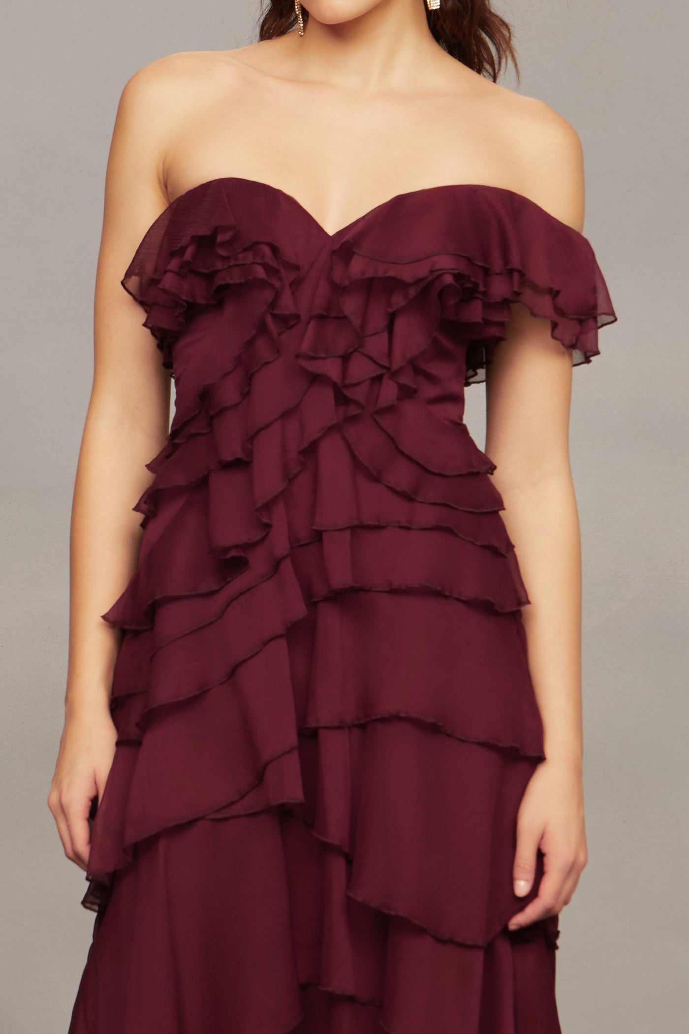 Maroon strapless ruffled dress on a plain background